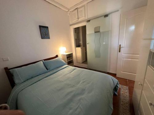 ein Schlafzimmer mit einem Bett und einer Tür zu einem Zimmer in der Unterkunft La alcazaba, résidence pieds dans l’eau à Sidi Rahal in Dar Mohammed Ould Haj Jilali