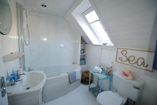 uma casa de banho com uma banheira, um lavatório e um WC. em Westshore House- fabulous waterfront home Fife em Pittenweem
