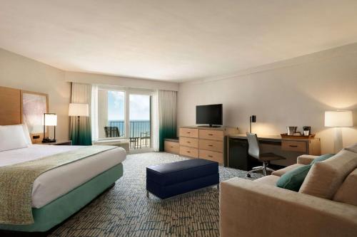Habitación de hotel con cama y escritorio en Surfbreak Virginia Beach Oceanfront, Ascend Hotel Collection en Virginia Beach