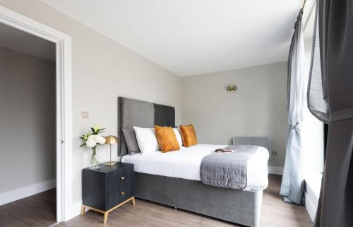 a bedroom with a large bed with orange pillows at Oxford Street Fitzrovia Apartments by D'Montrio in London
