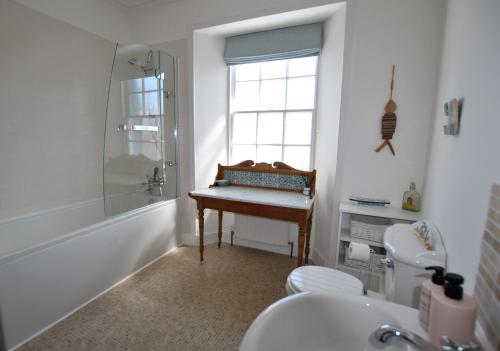 uma casa de banho com um lavatório, um chuveiro e uma secretária. em Turnstone- beautiful coastal home Pittenweem em Pittenweem