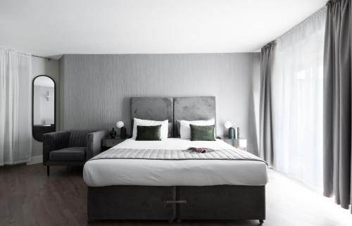 a bedroom with a large bed and a chair at Oxford Street Fitzrovia Apartments by D'Montrio in London