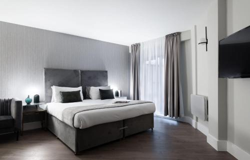 a bedroom with a large bed and a large window at Oxford Street Fitzrovia Apartments by D'Montrio in London