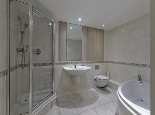 a bathroom with a shower and a sink and a toilet at Oxford Street Fitzrovia Apartments by D'Montrio in London