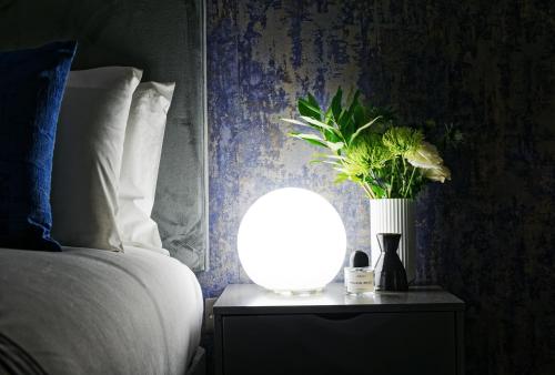a bedroom with a bed and a vase with flowers on a table at Oxford Street Fitzrovia Apartments by D'Montrio in London