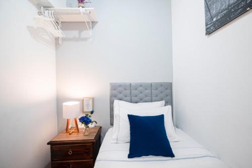 1 dormitorio con cama con almohada azul y mesita de noche en Hab Pequeña baño compartido La Paz 4, en Lima