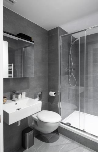 a bathroom with a toilet and a shower and a sink at Oxford Street Fitzrovia Apartments by D'Montrio in London