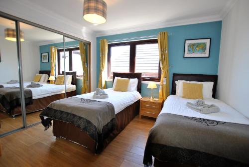 a bedroom with two beds and a large mirror at Kellie View near Anstruther in Carnbee