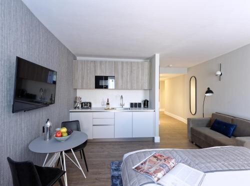a bedroom and living room with a bed and a table at Oxford Street Fitzrovia Apartments by D'Montrio in London