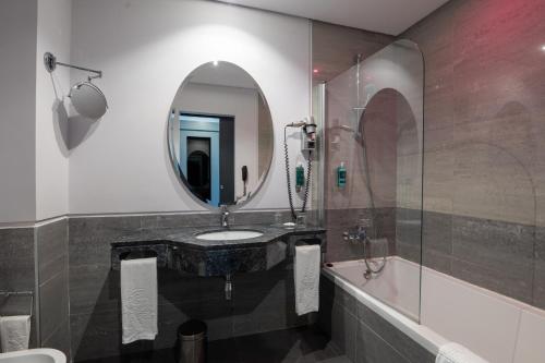 a bathroom with a sink and a mirror at Vila Gale Evora in Évora