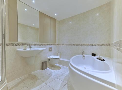 a bathroom with a tub and a sink and a toilet at Oxford Street Fitzrovia Apartments by D'Montrio in London