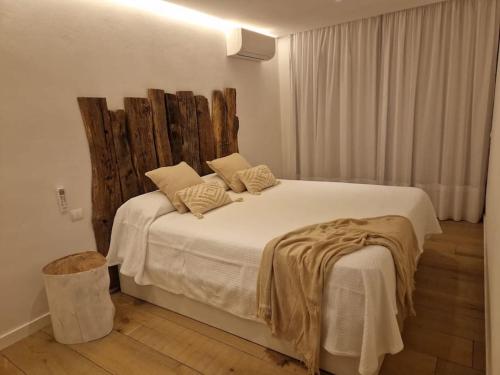 a bedroom with a large white bed with a wooden headboard at El balcon de formentera in La Savina