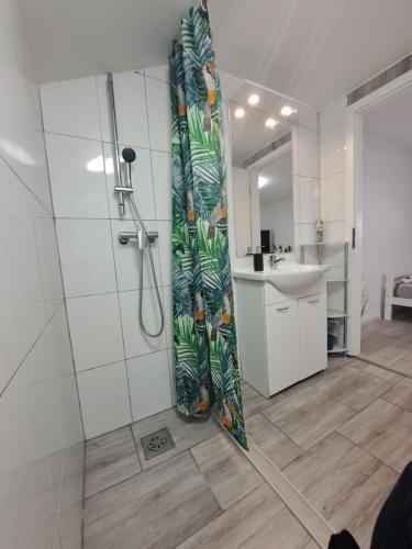y baño con ducha y cortina de ducha. en Koča Martuljek en Gozd Martuljek