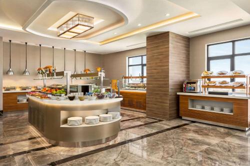 un ristorante cucina con bancone con cibo di Ramada by Wyndham Karapinar a Karapınar