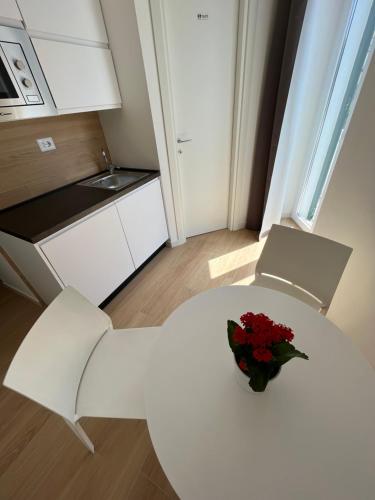 a white table with a vase of flowers on it in a kitchen at Summertime in Bisceglie
