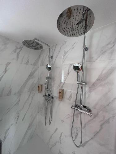 a bathroom with two shower heads on a marble wall at Alojamiento Luz de Hadas in Sampil