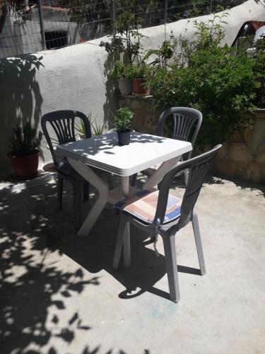 un tavolo bianco e due sedie con piante sopra di PYLOS GEM a Pylos