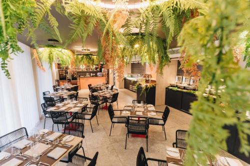 a restaurant with tables and chairs and plants at IKYK Hotel- IK Collection in St Julian's