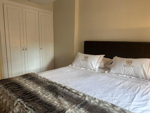a bedroom with a bed with white sheets and pillows at Alojamiento Luz de Hadas in Sampil