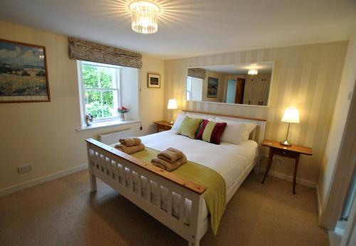 ein Schlafzimmer mit einem großen Bett mit zwei Stofftieren darauf in der Unterkunft Woods Neuk-stunning character cottage East Neuk in Pittenweem