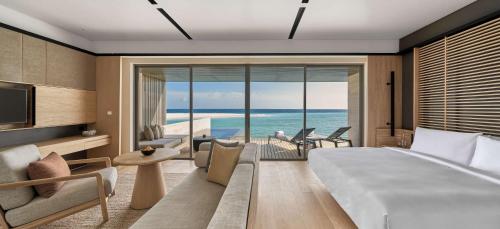 a bedroom with a bed and a view of the ocean at Alila Kothaifaru Maldives 