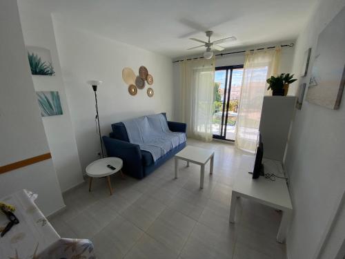 een woonkamer met een blauwe bank en een tafel bij Apartamentos Porta Mediterranea Altamar in Alcossebre