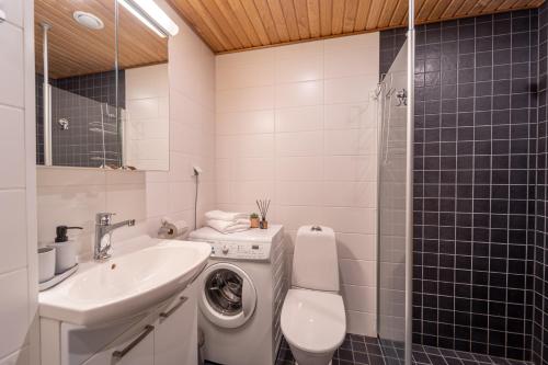 ein Badezimmer mit einem Waschbecken und einer Waschmaschine in der Unterkunft Sun Villas A23 in Kalajoki