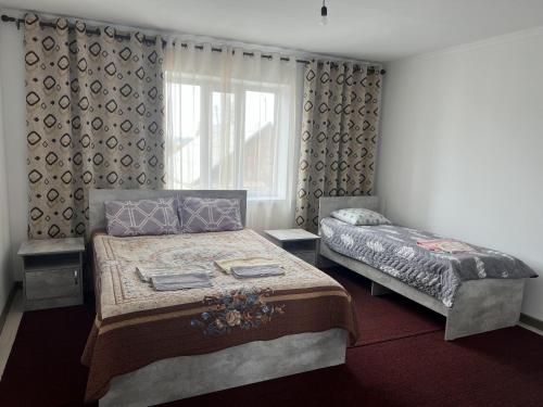 a bedroom with two beds and a window at Guest House Baytur in Kochkorka