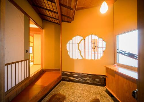 a hallway with an orange wall with a window at Haiya in Awara