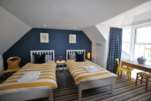 2 camas en una habitación con paredes azules en Shore Cottage Anstruther- stylish home by the sea, en Anstruther