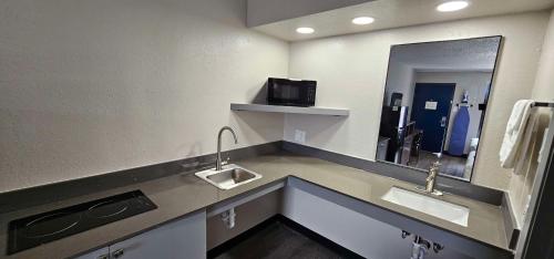 a bathroom with two sinks and a mirror at SureStay Studio by Best Western Victoria in Victoria