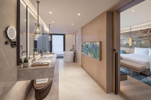 a hotel room with a bed and a bathroom at JW Marriott Goa in Vagator