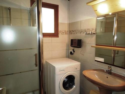 une petite salle de bains avec un lave-linge et un lavabo dans l'établissement Pley - Seignosse agréable villa landaise dans secteur calme et résidentiel sur vaste jardin clos, à Seignosse