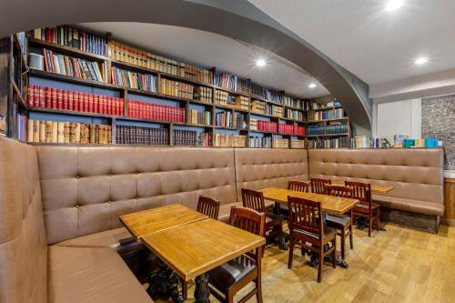 a restaurant with tables and chairs in a library at The Arlington Hotel - BW Signature Collection in Paris
