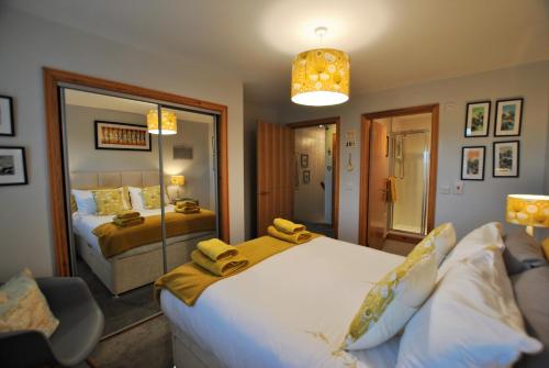 a bedroom with a large bed and a mirror at Jessies Selkie- homely apartment in East Neuk in Anstruther