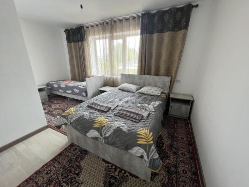 a bedroom with a bed and a couch and a window at Guest House Baytur in Kochkor