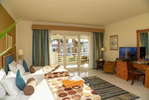 sala de estar con 2 camas y escritorio en Golf Beach Resort - Ultra All Inclusive, en Sharm El Sheikh