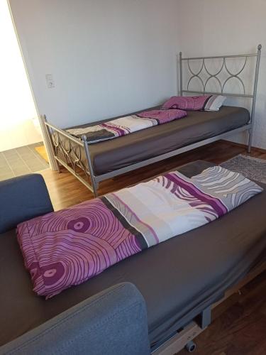 two bunk beds in a room with purple and white sheets at Zimmer "Beere" in Lahr-Dinglingen