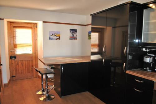 a kitchen with a counter and a bar with a stool at Sand And Sea Cottage- lovely family home Crail in Crail