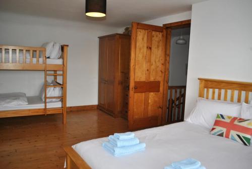 ein Schlafzimmer mit einem Bett und einem Etagenbett in der Unterkunft Sand And Sea Cottage- lovely family home Crail in Crail