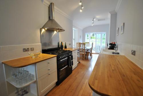 a kitchen with a stove and a wooden floor at Harbour House- home from home in Pittenweem in Pittenweem