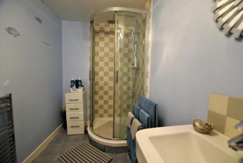 a bathroom with a shower and a sink at Oyster Cottage- relaxing retreat by the sea in Saint Monance