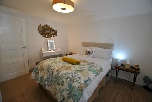 a bedroom with a bed with a yellow pillow on it at Oyster Cottage- relaxing retreat by the sea in Saint Monance