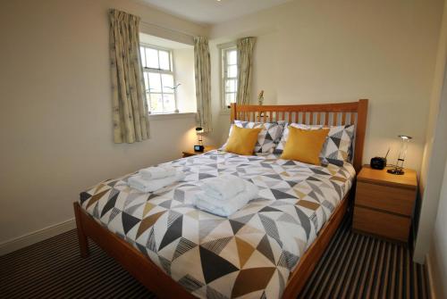 a bedroom with a large bed with pillows at Dolphin Cottage- traditional cottage on Fife Coast in Anstruther