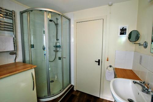 a bathroom with a glass shower and a sink at Dolphin Cottage- traditional cottage on Fife Coast in Anstruther