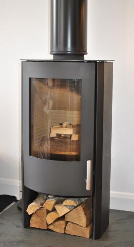 a television sitting on top of a pile of logs at Academy Apartment Anstruther- stunning luxury home in Anstruther