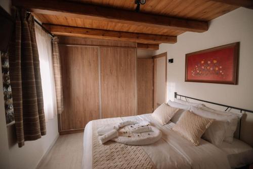 una camera con letto bianco e soffitto in legno di Mesostrati Μanor Ηouse 