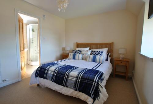 a bedroom with a bed with a blue and white blanket at Seaview Steading-spacious home in rural location in Crail