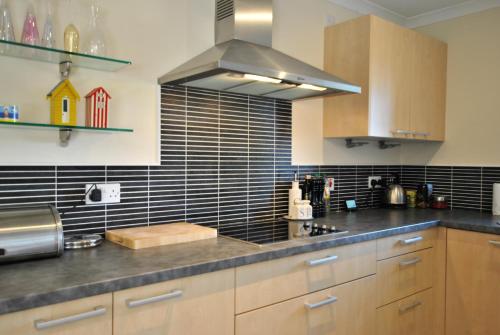 a kitchen with wooden cabinets and a stove top oven at Seaview Steading-spacious home in rural location in Crail