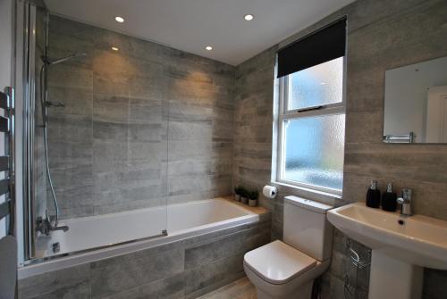 a bathroom with a tub and a toilet and a sink at Creel Cottage- stylish cottage near the sea in Anstruther